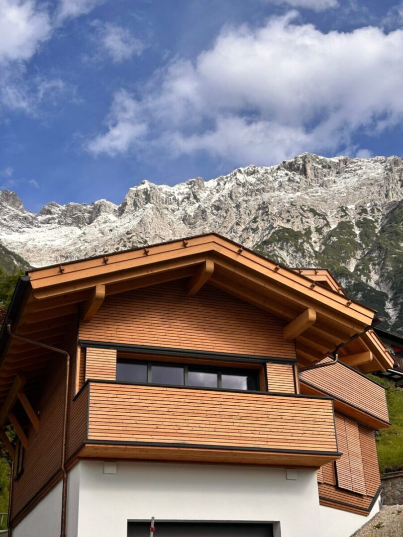Wooden chalet set against the dramatic backdrop of the Austrian Alps.